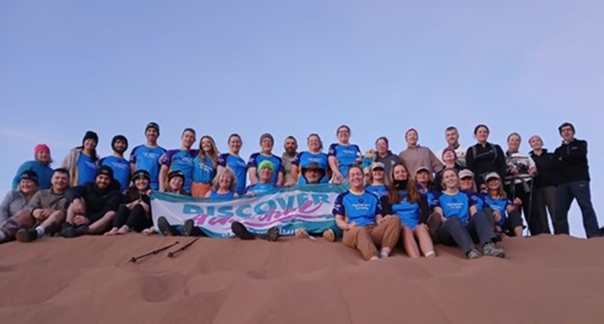 The team of Sahara Trek finishers on top of a sand dune