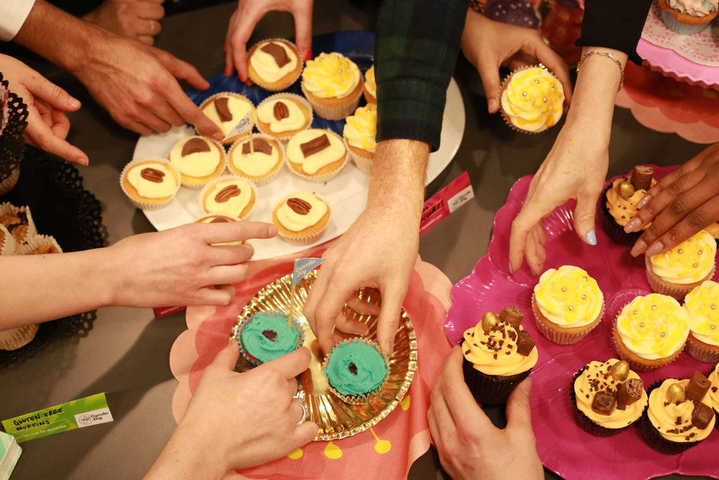 Hands grabbing at cupcakes