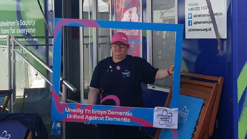 Ceri Higgins holding up a blue Alzheimer's Society frame