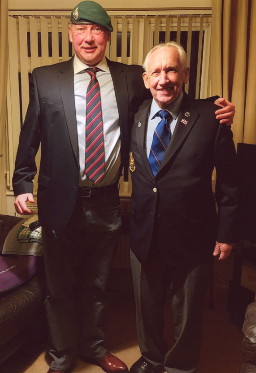 Father and son stand close in their formal military suits.
