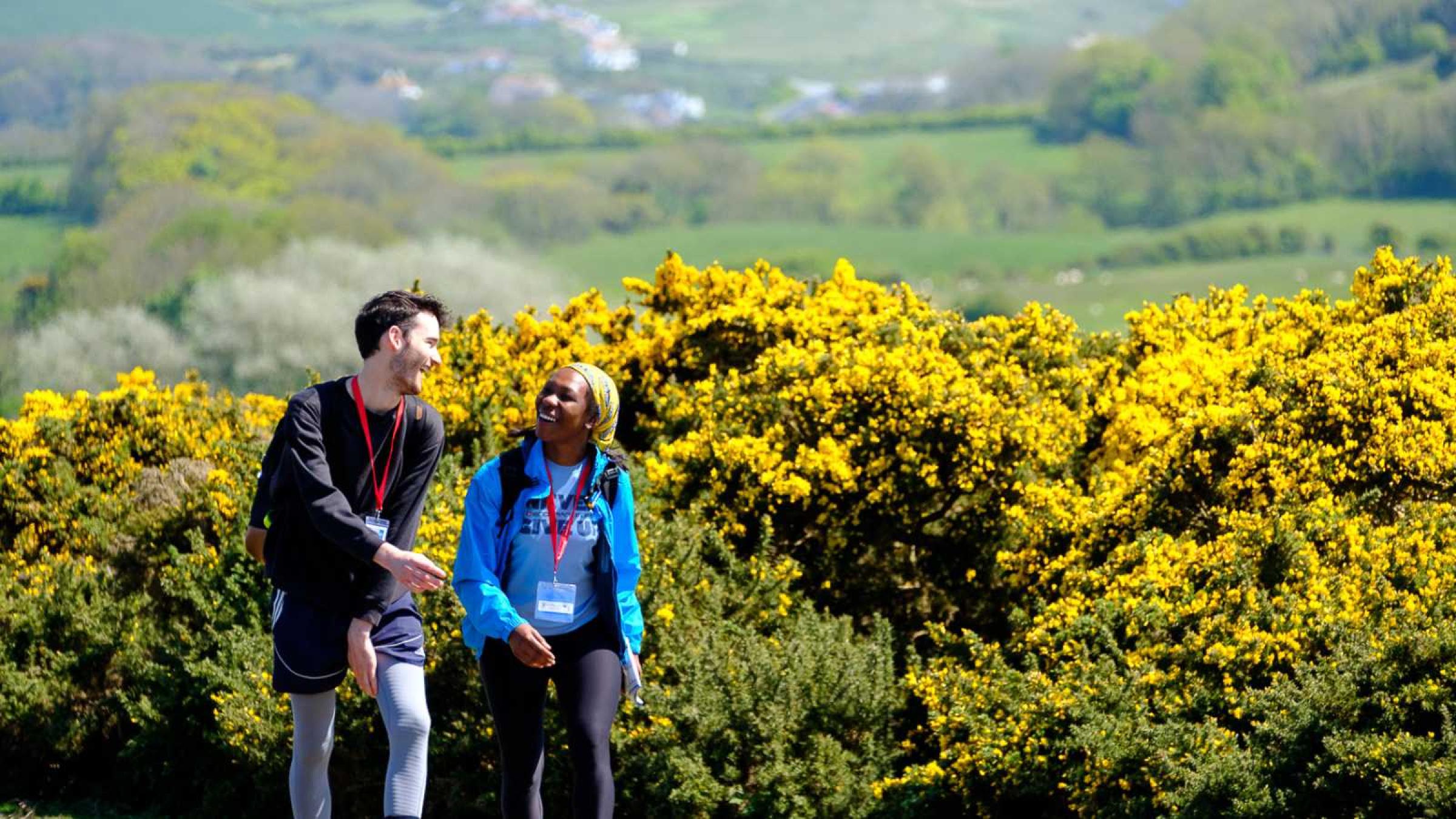 A man and a woman walking in a field