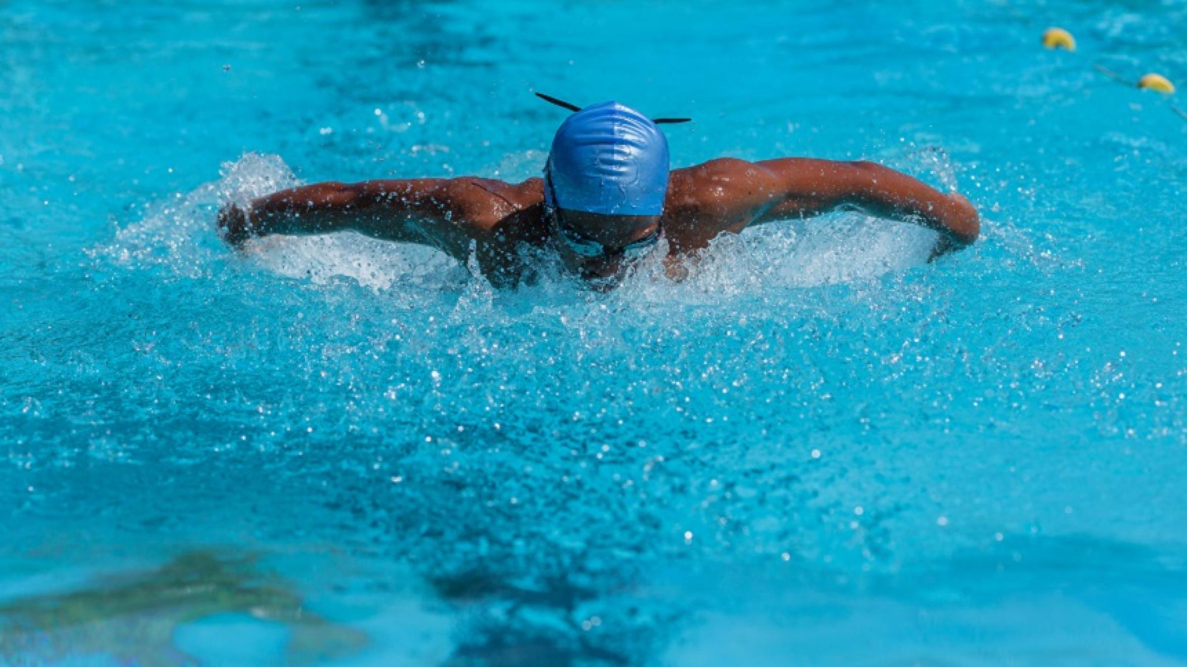 Man swimming butterfly in a pool.