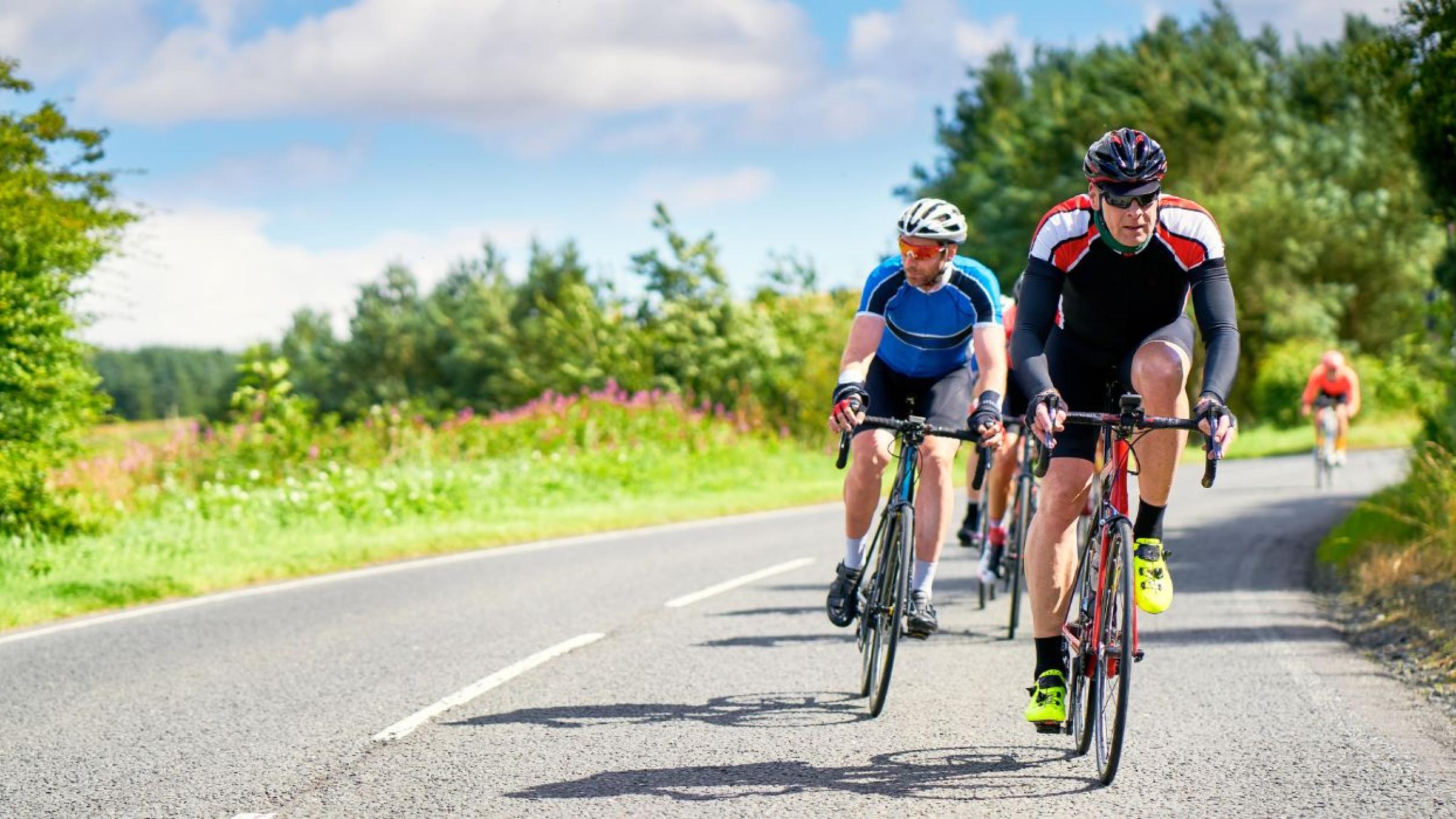 Group of people cycling along a road