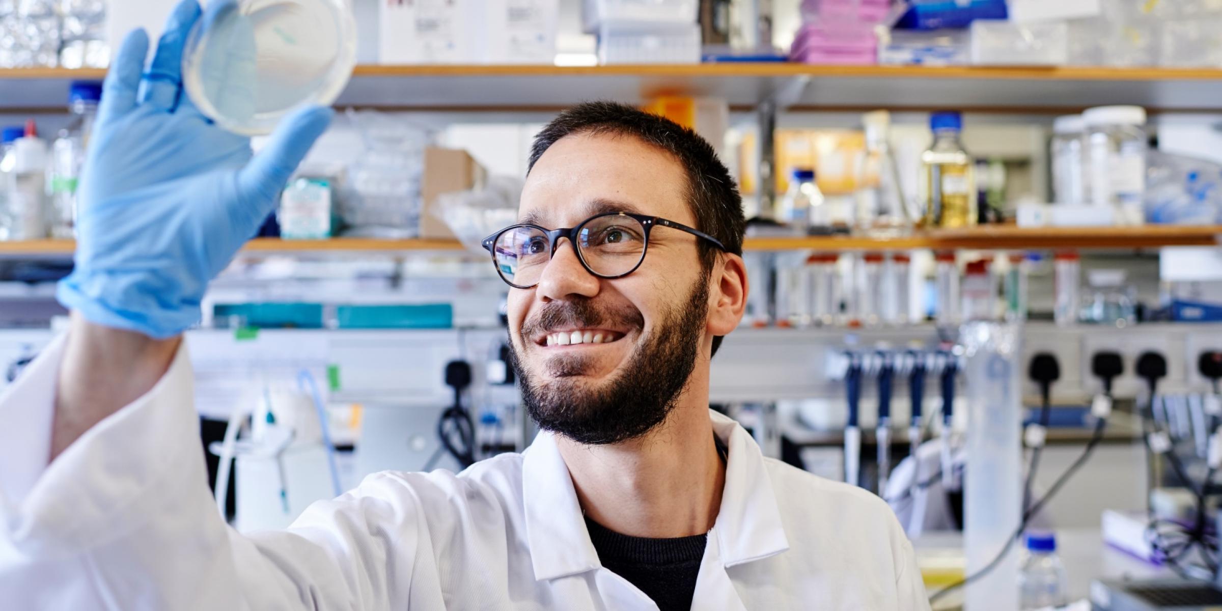 Researcher looking at petri dish in lab