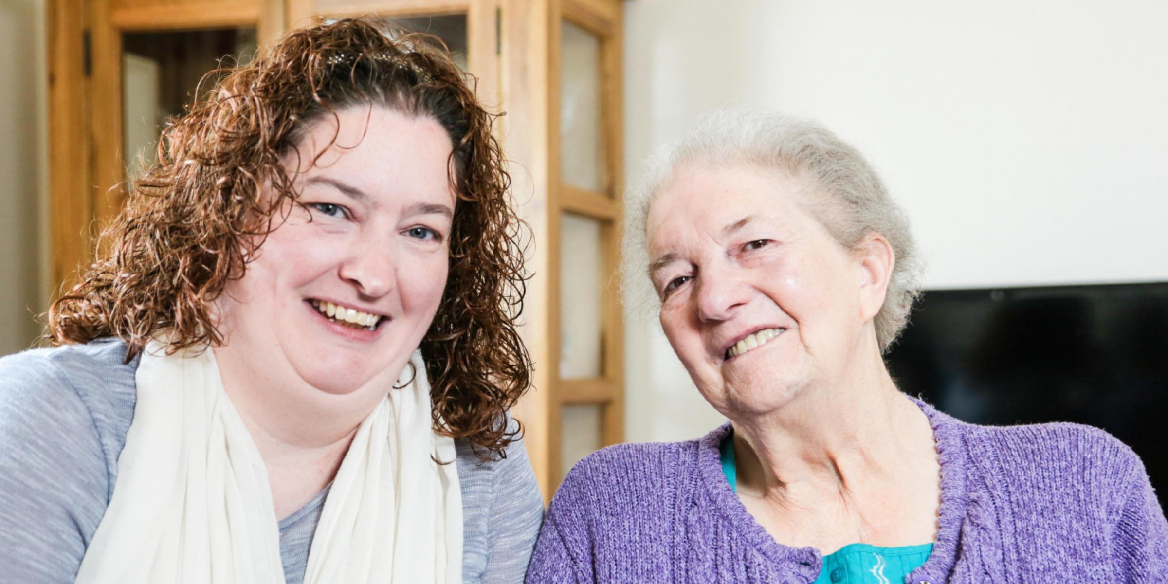 A carer smiling with a person with dementia