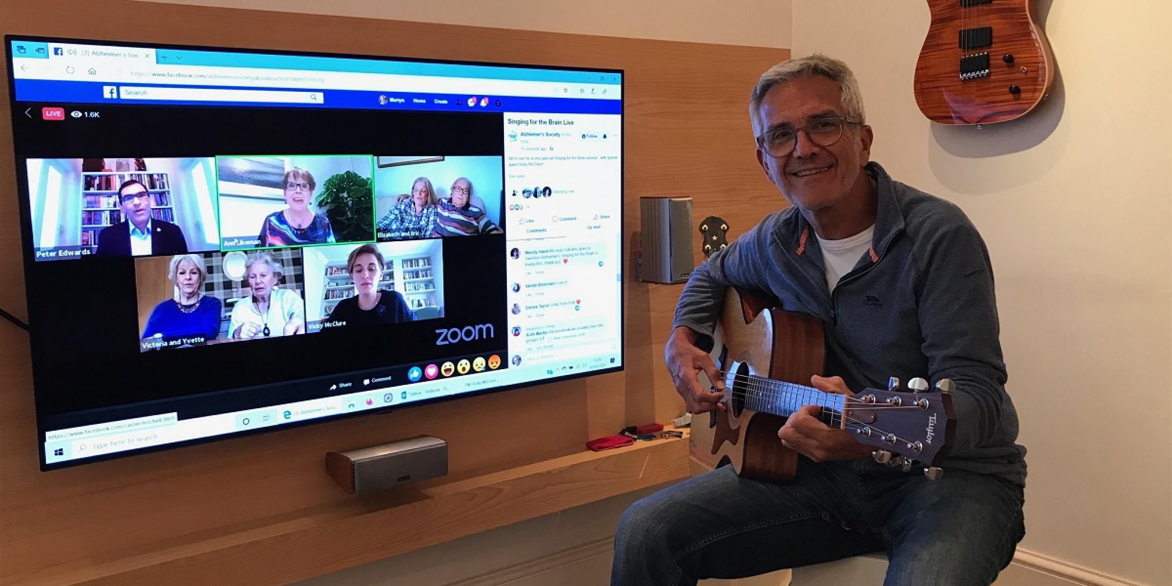 Martyn plays guitar along to Singing for the Brain Live