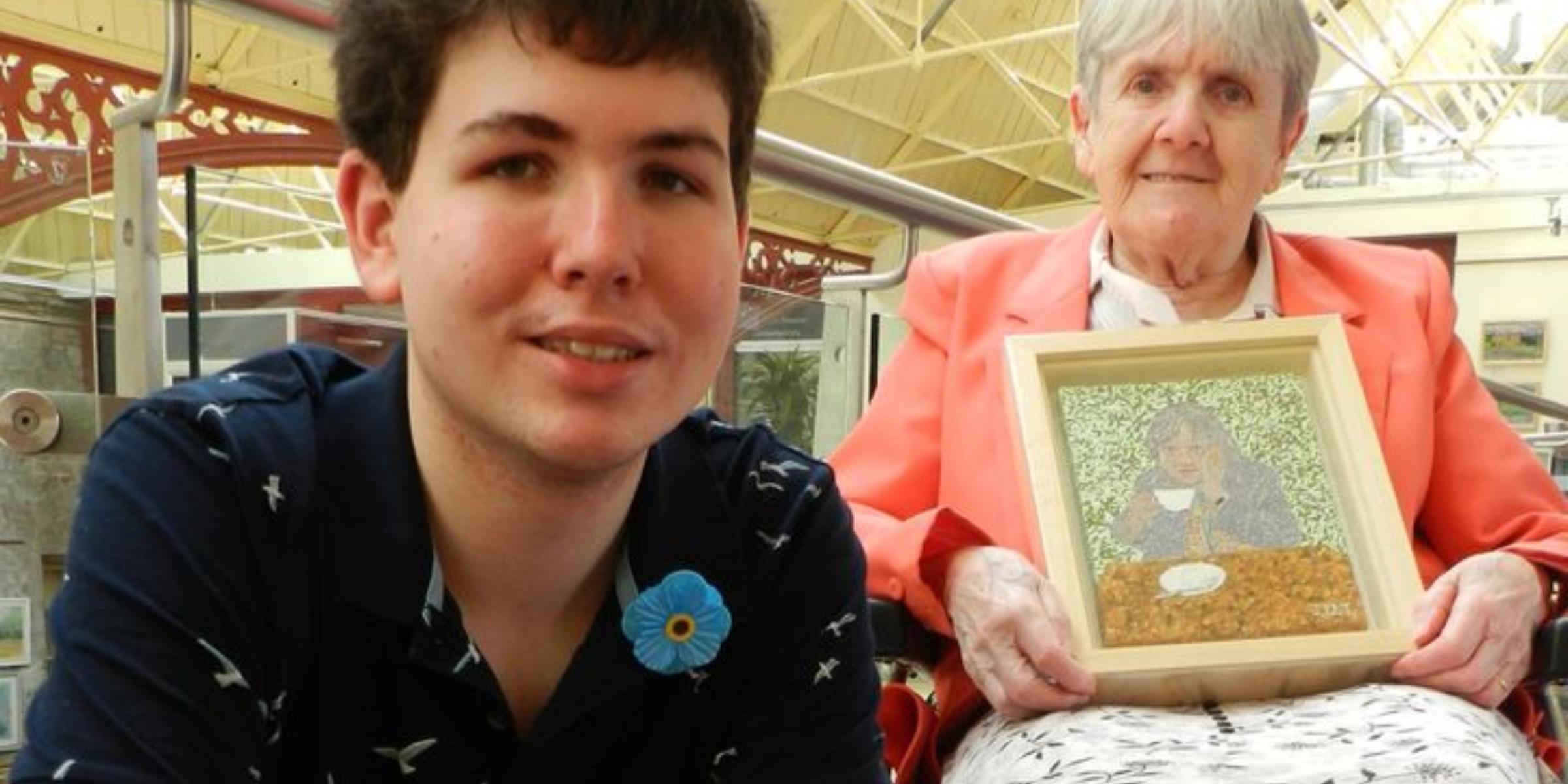 James with his grandmother Joan who holds up her artwork