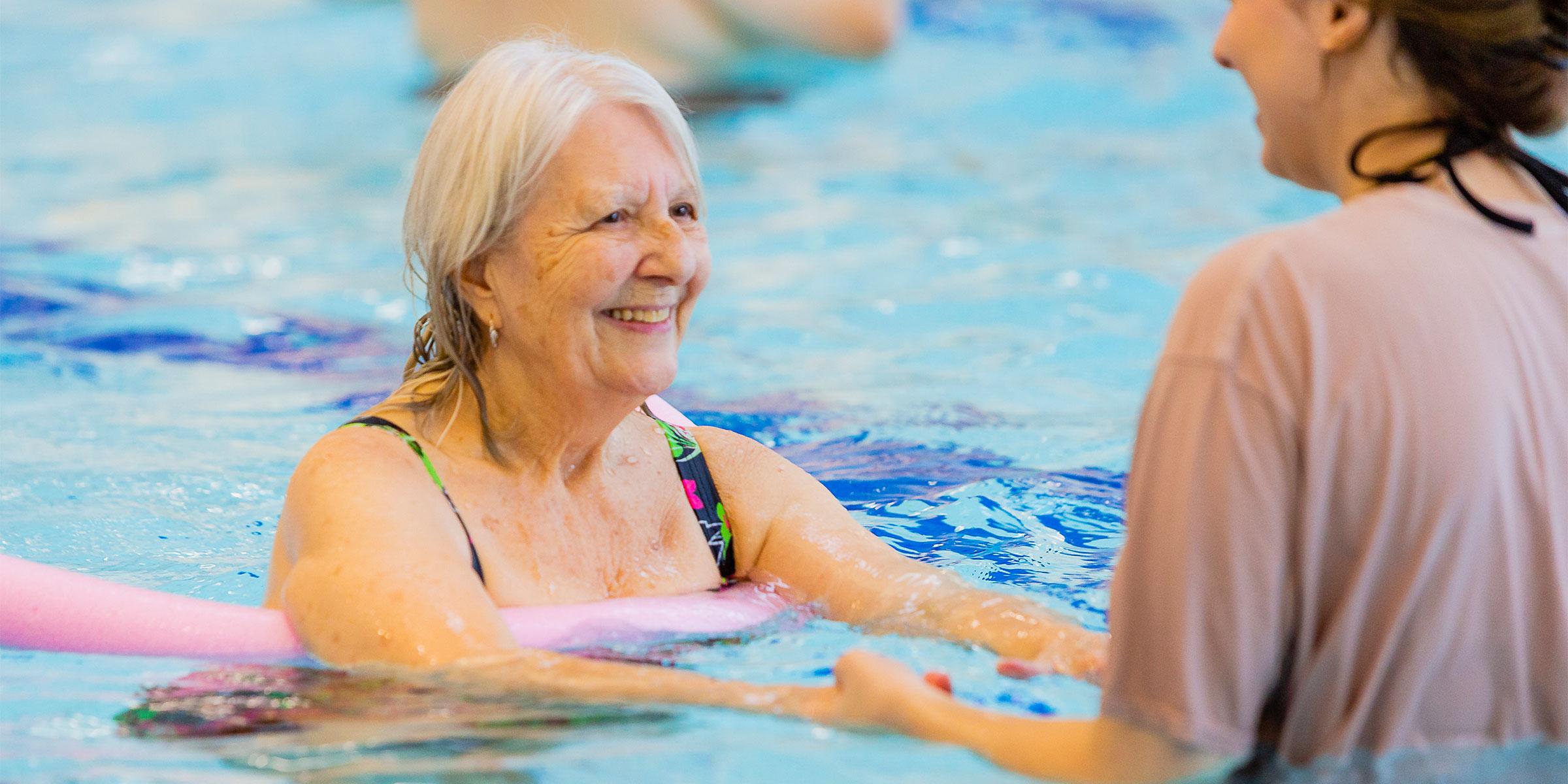 Person in swimming pool with occupational therapist