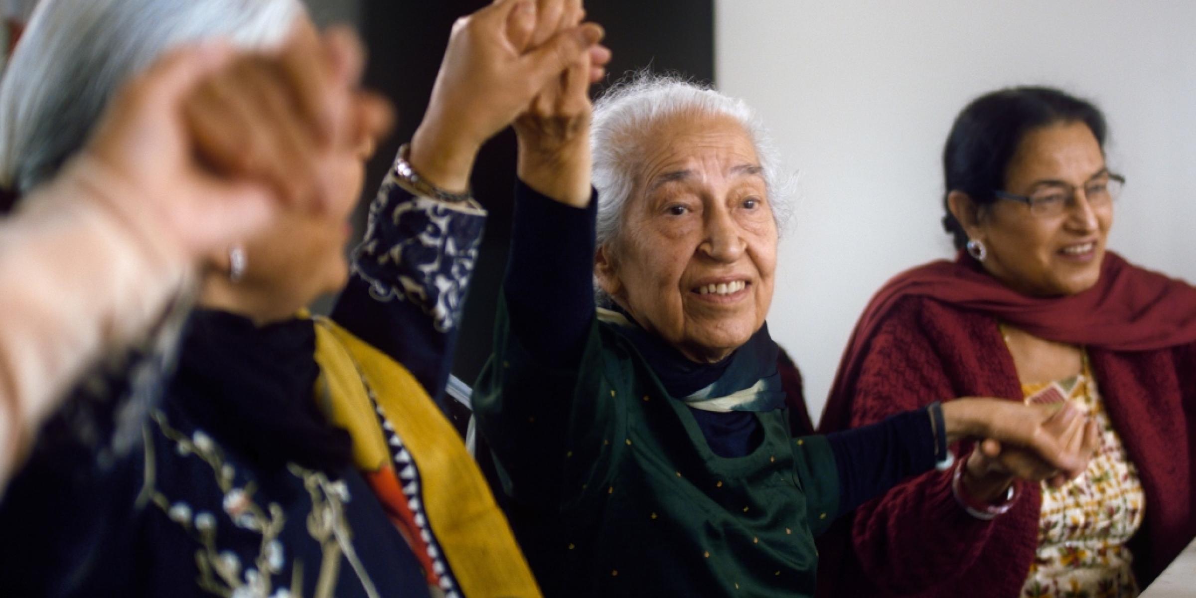 Bhagwant and some of the women from her community group, holding hands and singing
