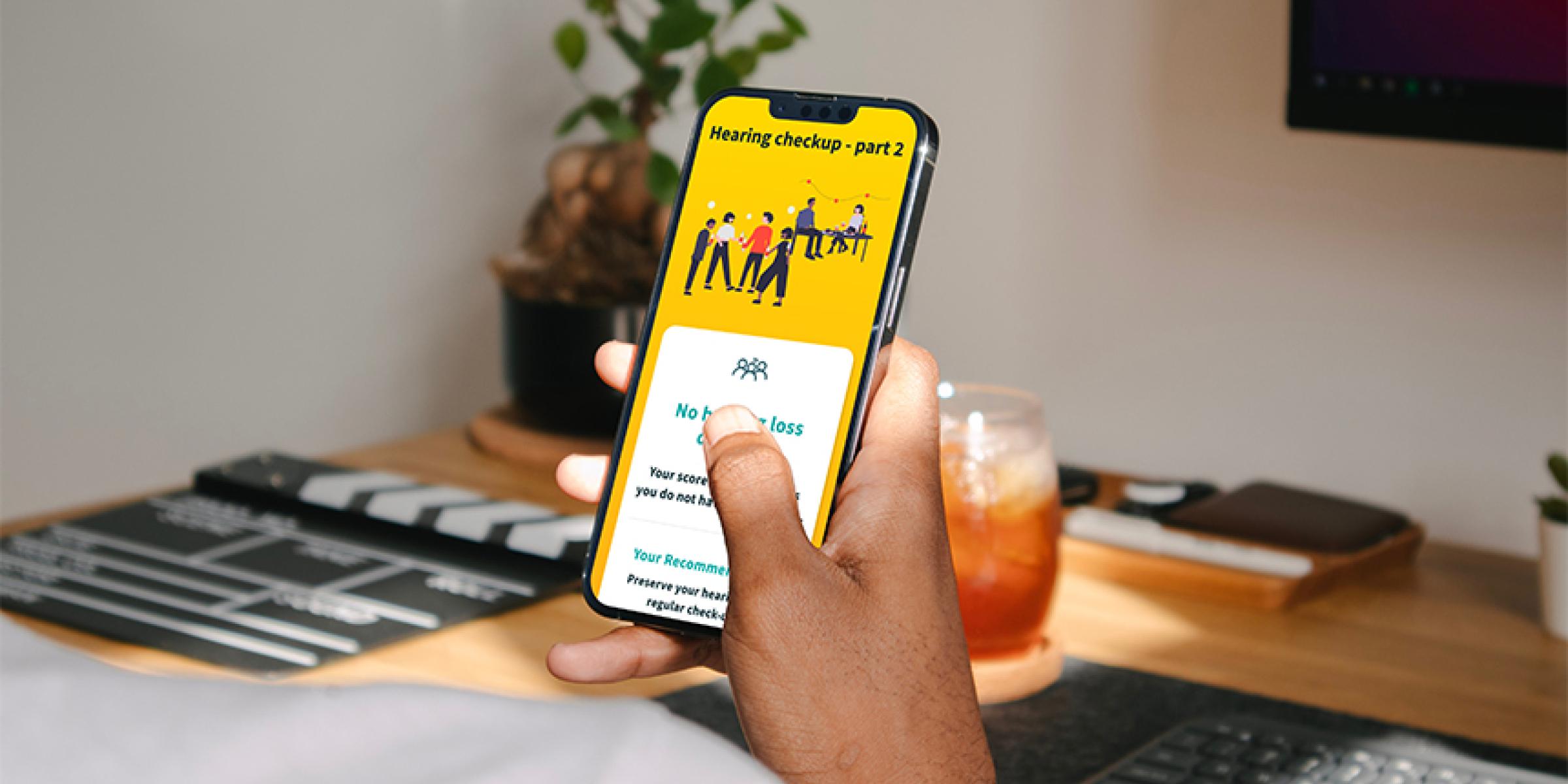 Someone holding a smartphone displaying the Eargym app