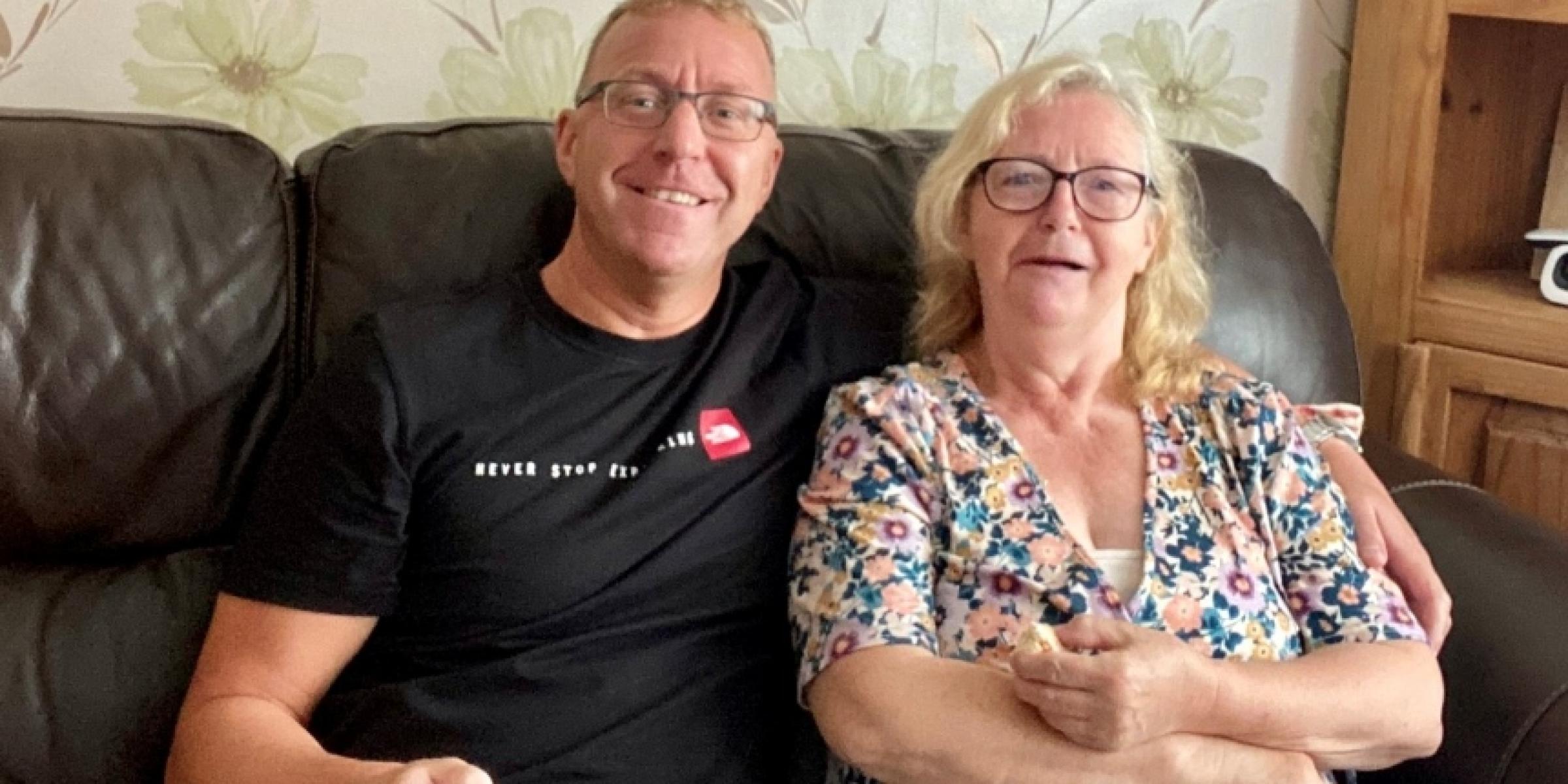 Alan and his mum Jackie arm in arm on the sofa