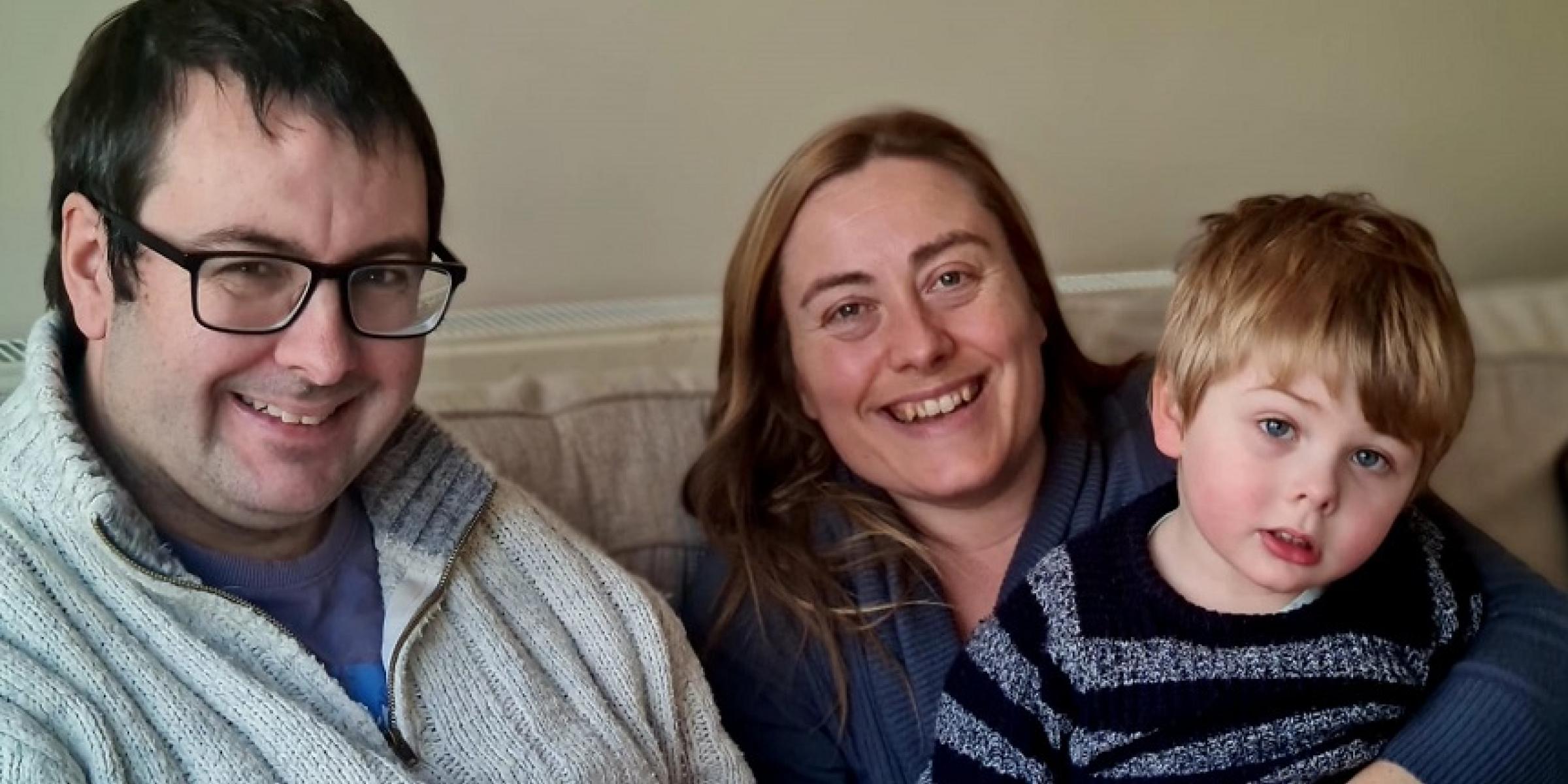 Mark, Caroline and William sitting together on a sofa