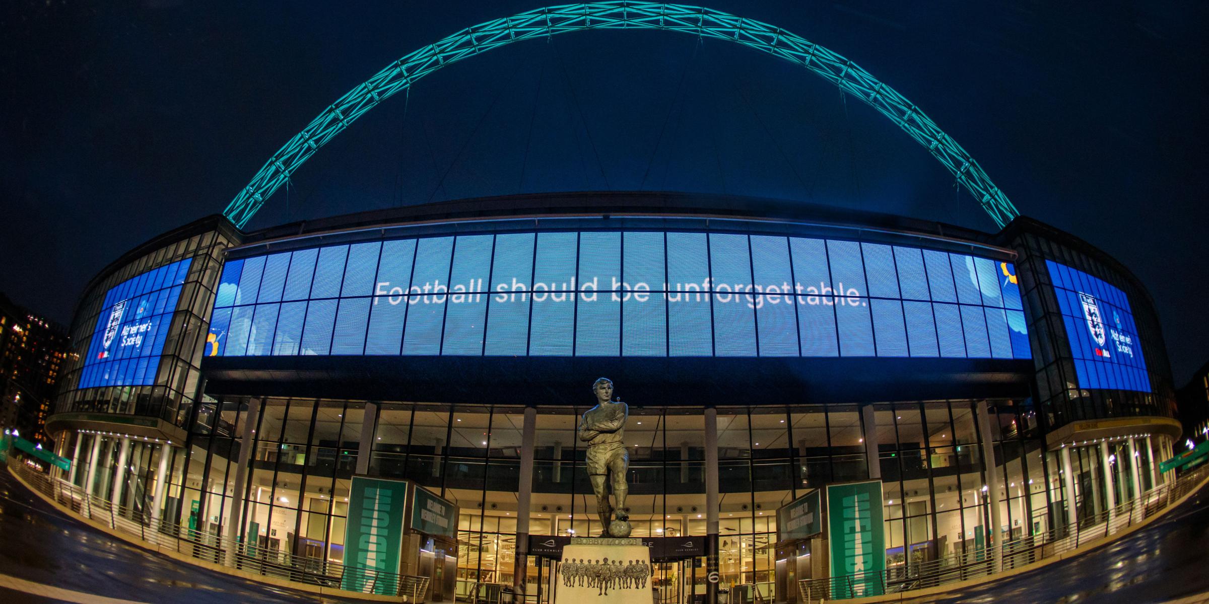 Wembley stadium lit up with the words 'football should be unforgettable'