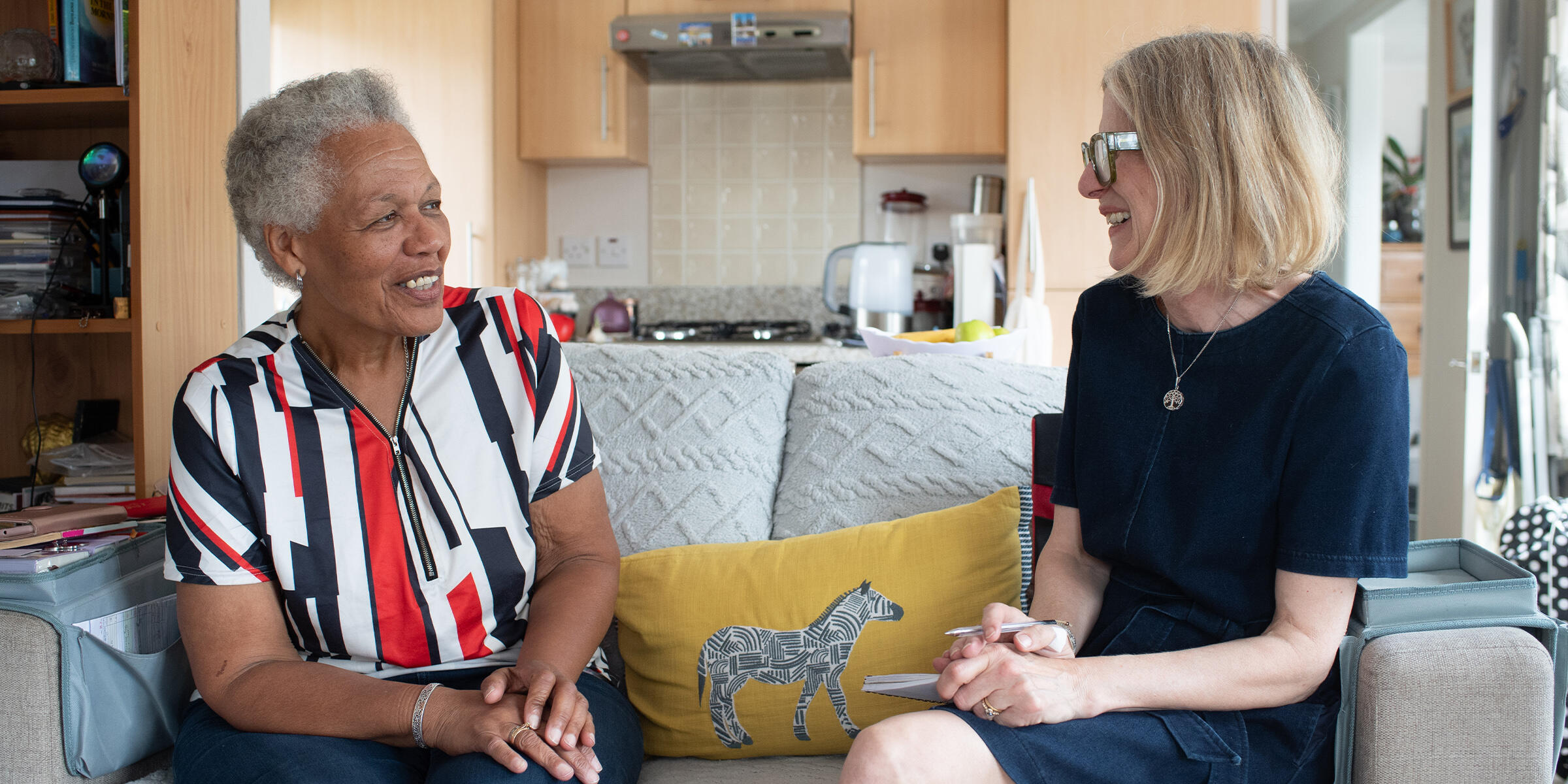 Coral Bayley speaking to writer Heather Stephen, both sitting on a sofa
