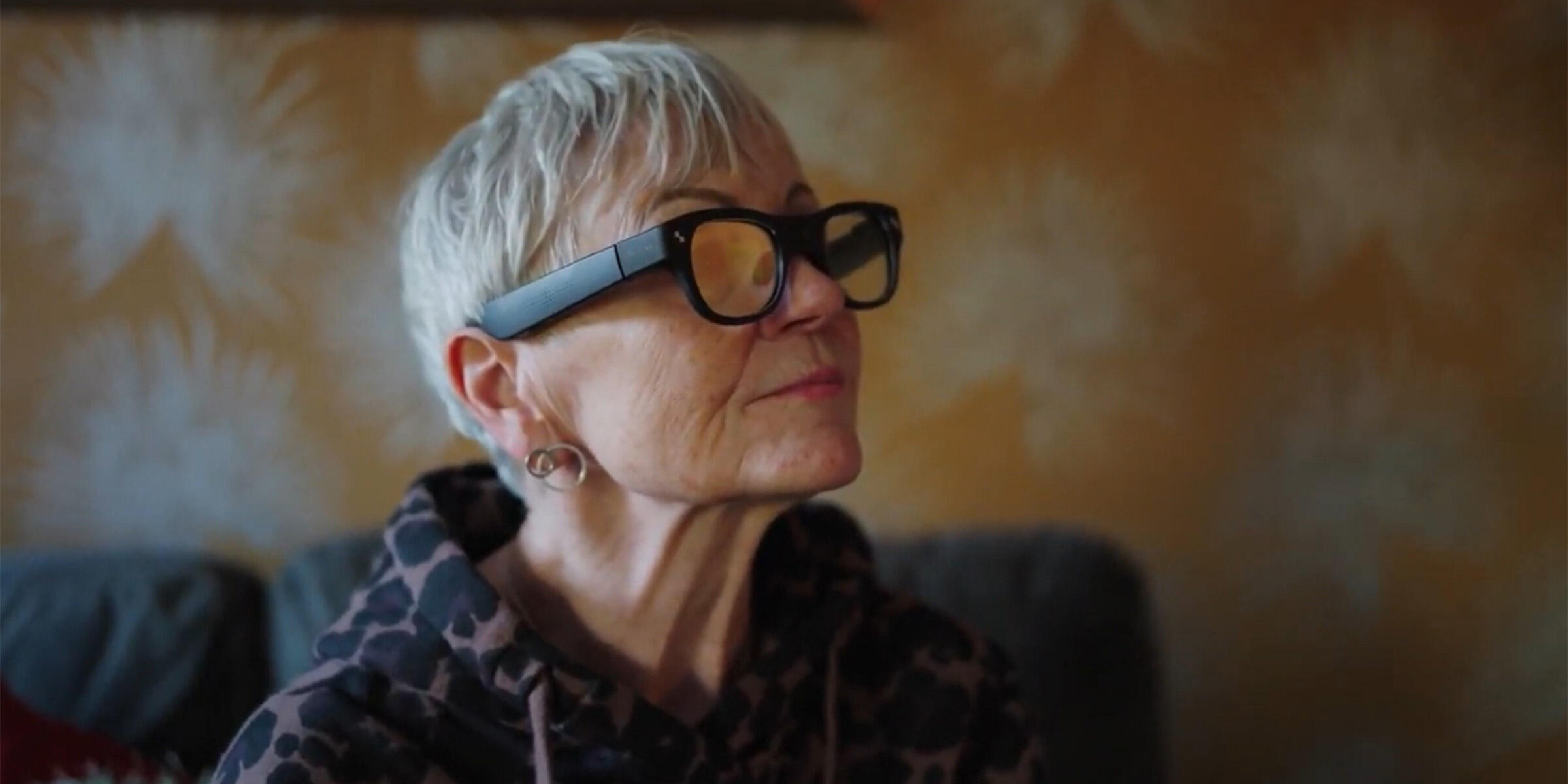 Carole Grieg wearing smart glasses and looking across a room