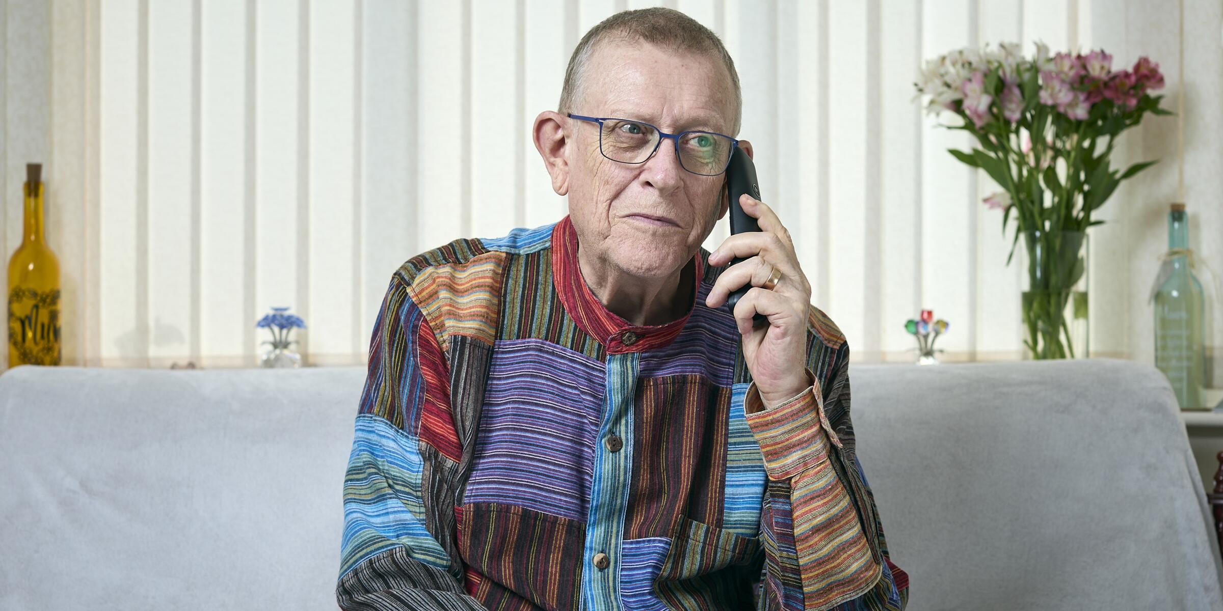 Pete Middleton sat on a sofa while on his mobile