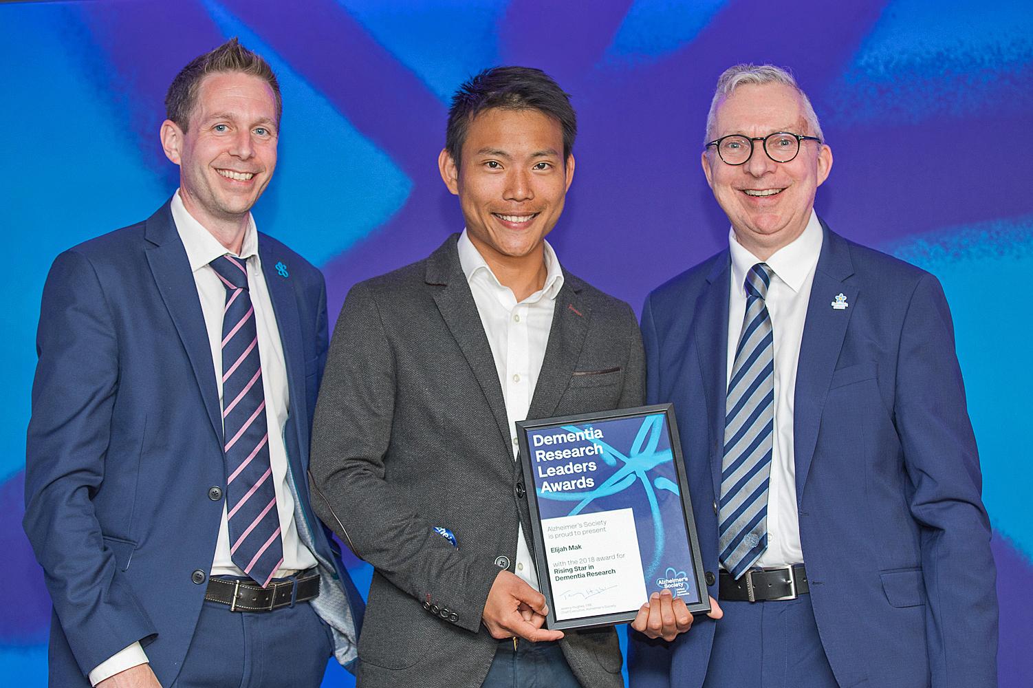 Elijah Mak with Jeremy Hughes winning his award