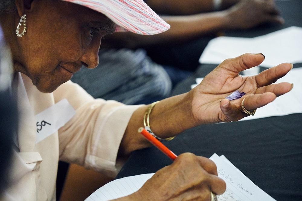 A woman with dementia writing a poem during the poetry workshop