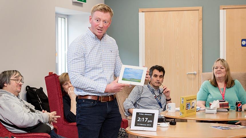 Oli Story showing the Rosebud reminder clock to people with dementia