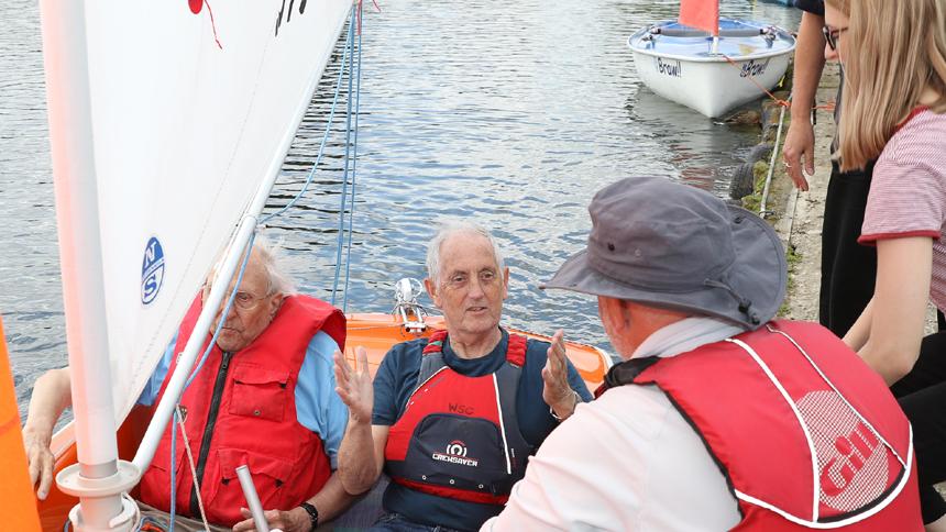 Two men in a boat chatting to other people at Whitefriars Sailing Club