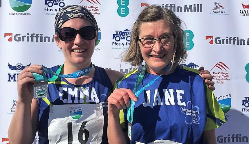 Jane pictured holding a medal after completing a half marathon for Alzheimer's Society
