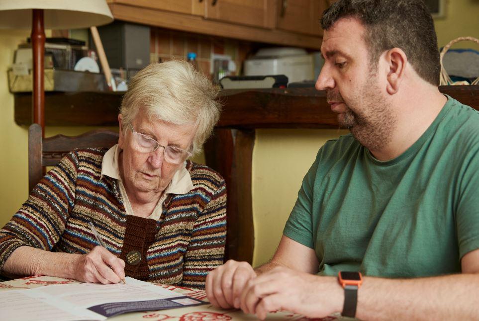 Two people at a table doing paperwork