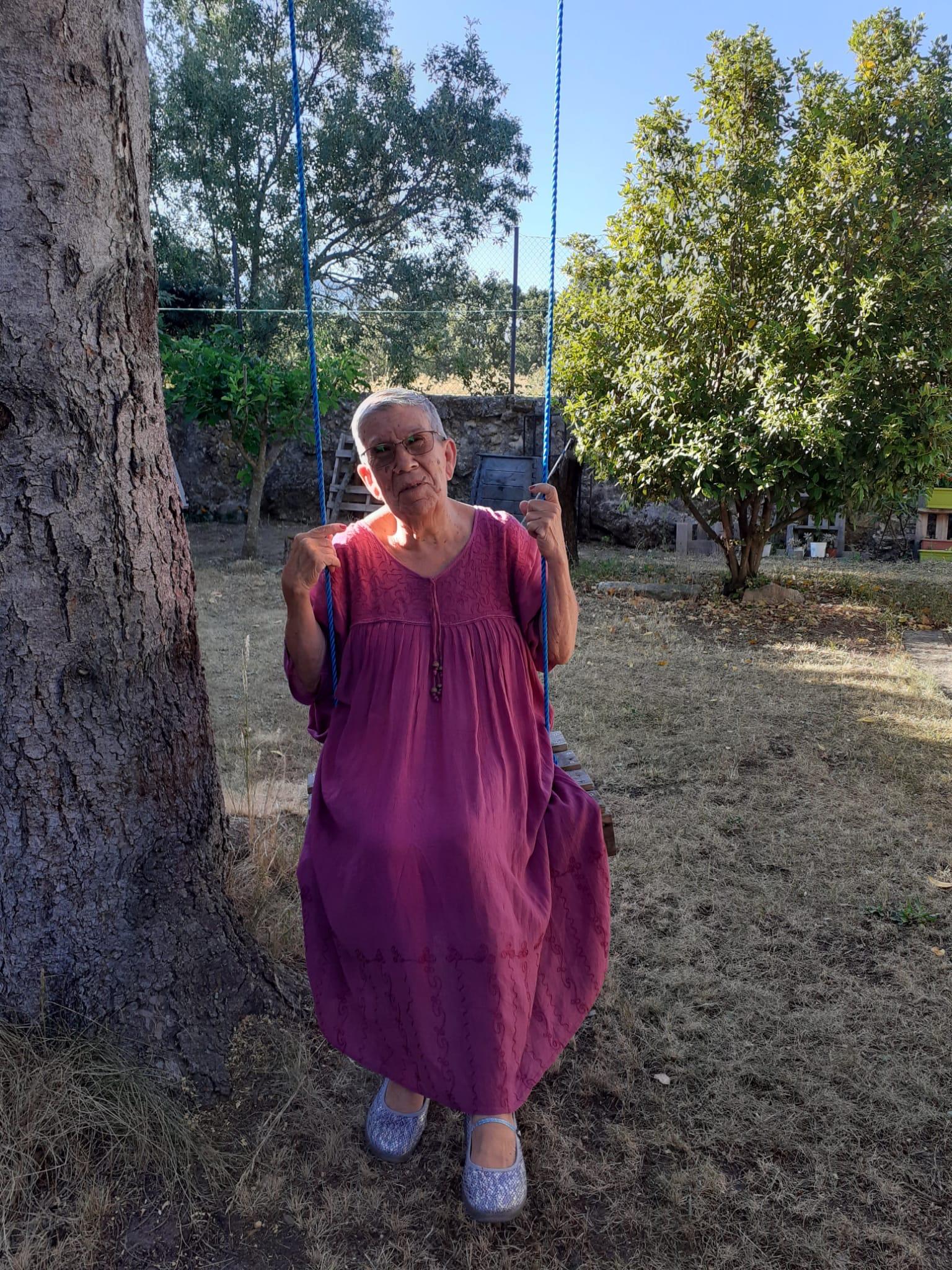 Lucas' grandma, sat on a swing below a tree