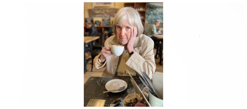 James' grandmother Joan drinking from a cup and saucer with one hand against her face
