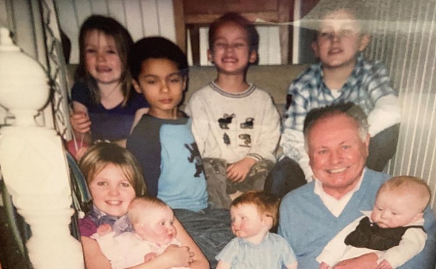 Bill Mann pictured with his grandchildren on a staircase
