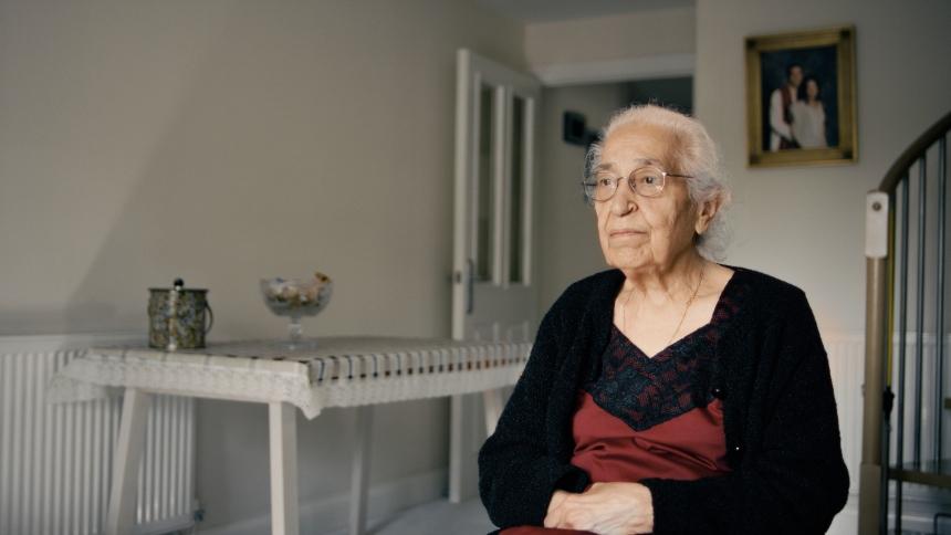 Bhagwant sat in a chair in her living room, looking concerned
