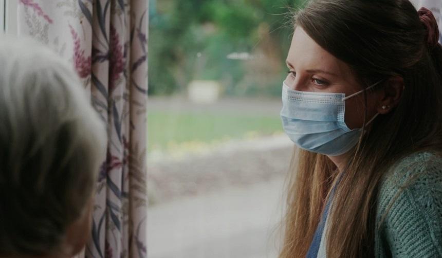 Saskia wearing a facemask talking to her mum in her care home
