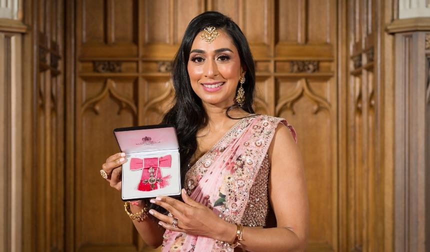 Lavina holding up her MBE 