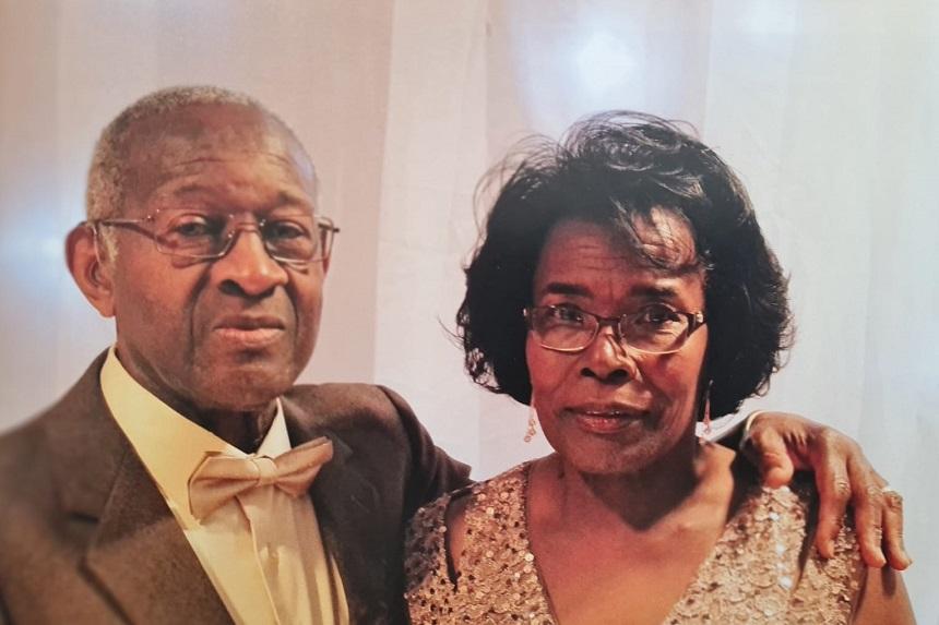 Raymond and Cynthia stand next to each other in smart clothes