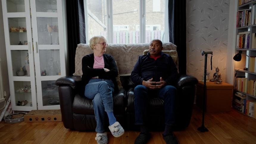 Ananga and Jo sitting on their sofa