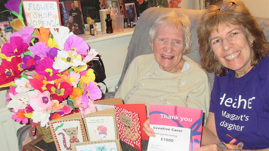Heather O'Neil and her mother with some paper flowers and a fundraising certificate from Alzheimer's Society