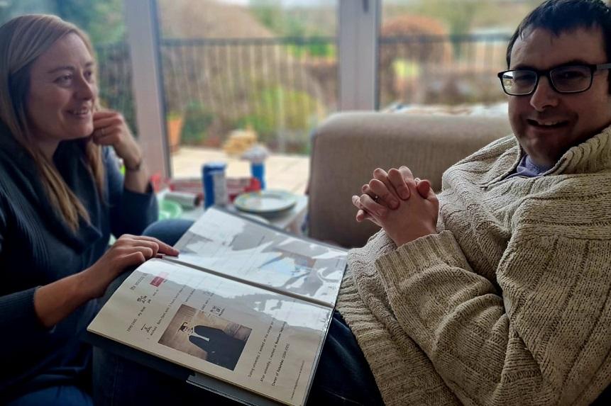 Mark and Caroline look at a book of photos