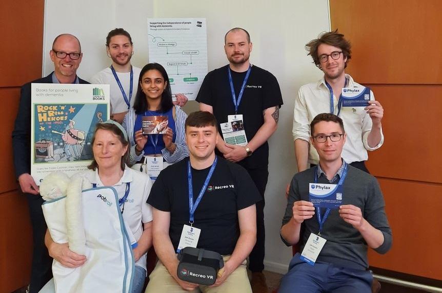 A group of people - the ASAP group -sit in front of a whiteboard and pose