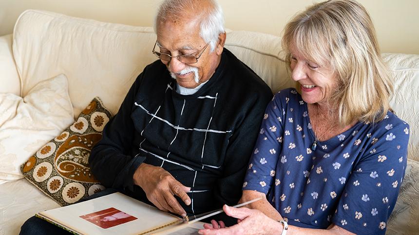 Rashmi and Maggie Paun look through a photo album together in their lounge