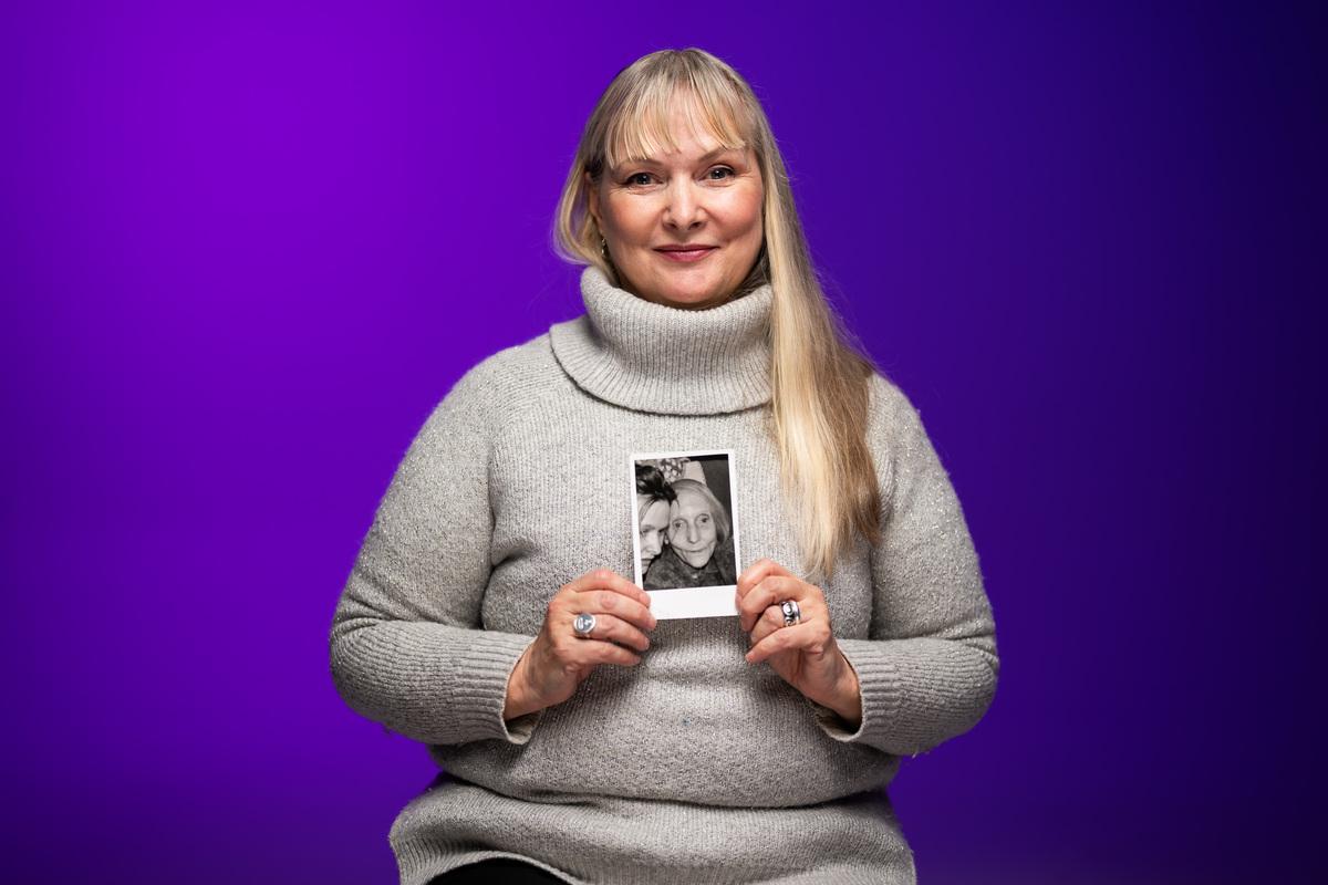 Our dementia storyteller Eugenie holds up a photo of her grandmother Elsie