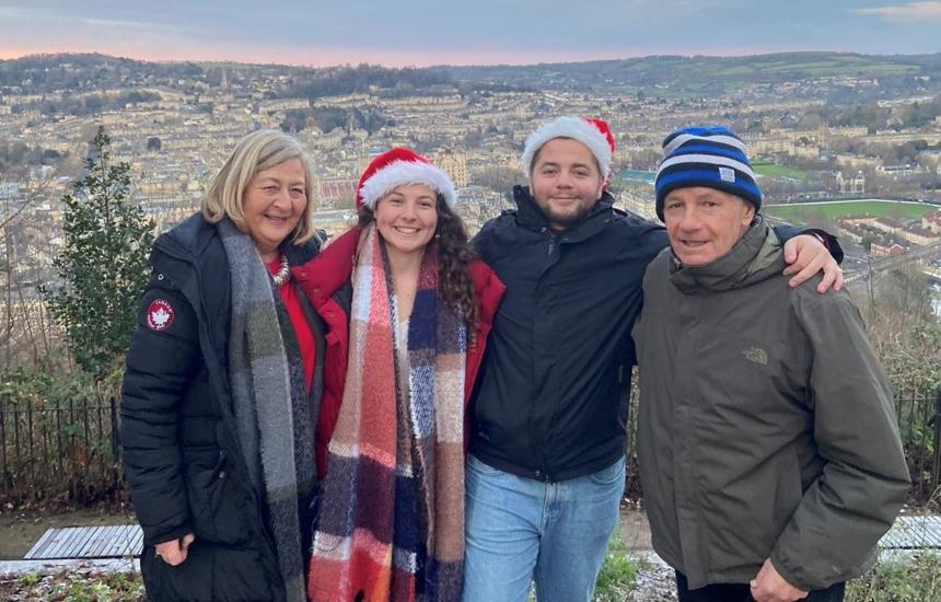 Nicky and Adrian with their children standing together in Christmas hats