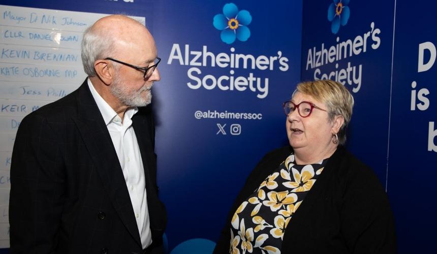 Michelle talking to someone with an Alzheimer's Society logo in the background
