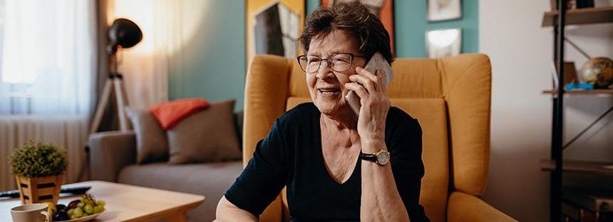 A woman is sat down and on the phone
