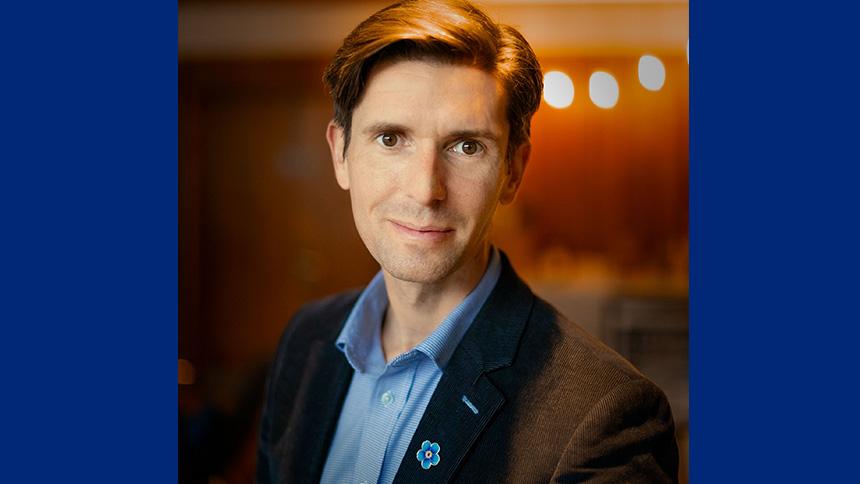 Dr Kamen Tsvetanov wearing a blue shirt and Alzheimer's Society pinbadge
