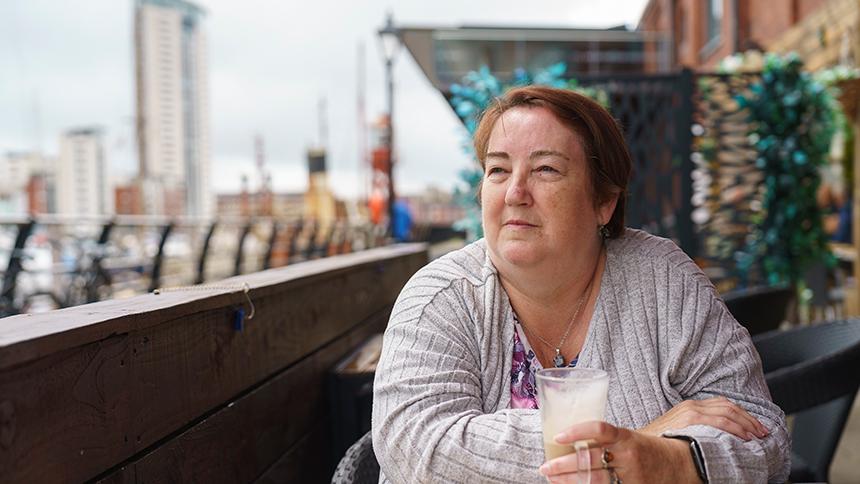 Dawn Davies sat outside drinking coffee and looking into the distance