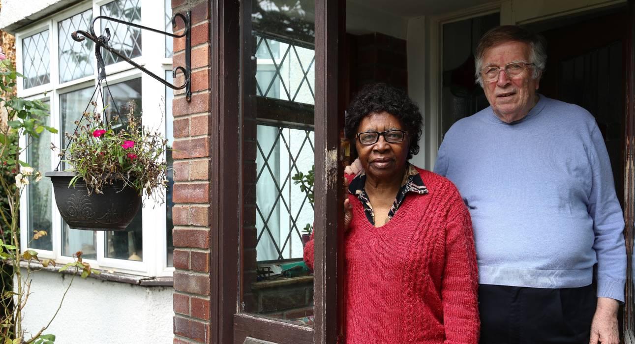 A couple standing outside their house