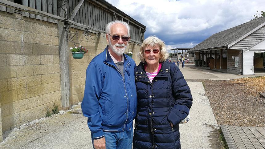 Brenda and her husband Alan stood in a farmyard on a sunny day