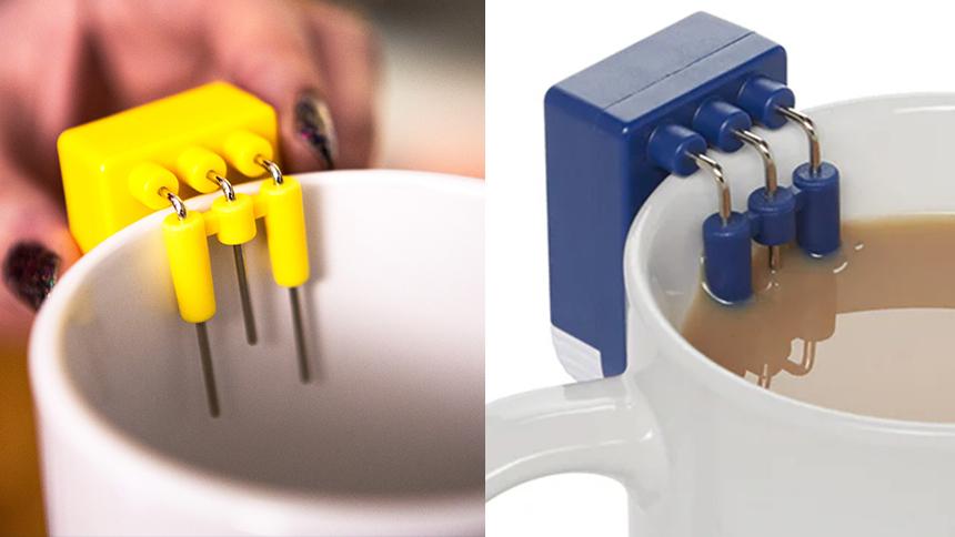Square yellow device with three long prongs placed on a white mug, blue version of same device in a full cup of tea.