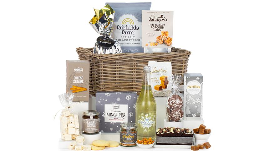 A hamper basket filled with alcohol-free foods and drinks, including mince pies, fudge and elderflower sparkle.
