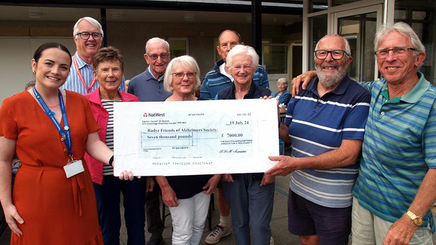 Eight members of the Radyr and Morganstown volunteer fundraising group present a large cheque to Alzheimer's Society.