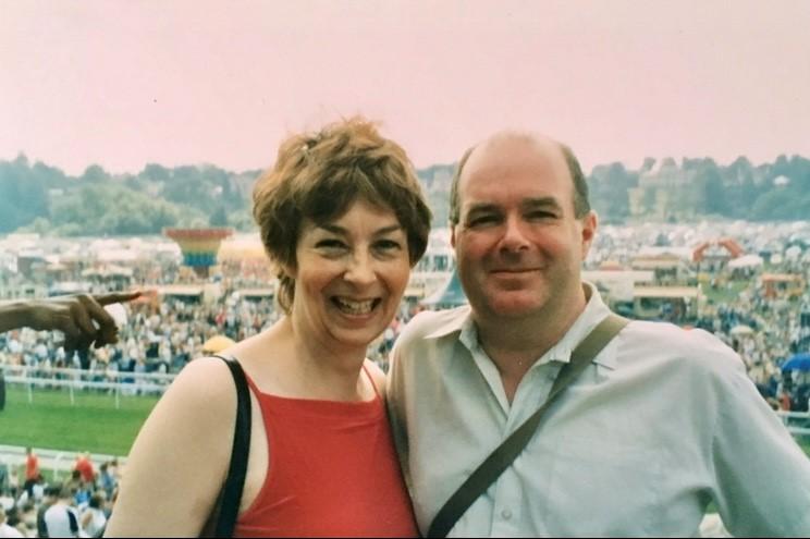 A man a woman stand together smiling